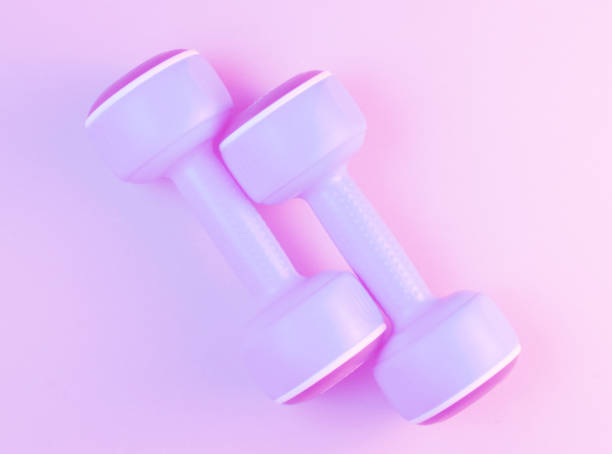 istock Minimalism sport concept. Two blue plastic dumbbells, pink holographic light. Top view 1203211012