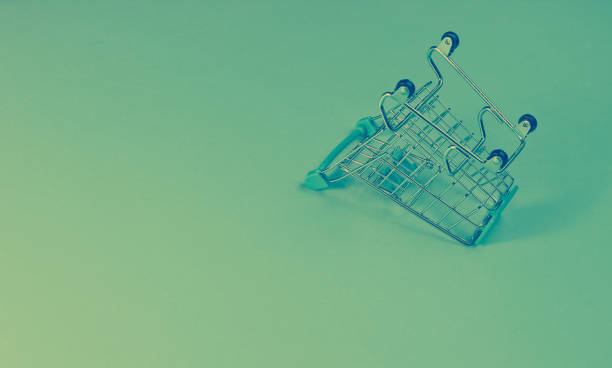 istock Minimalist shopping concept. Empty inverted miniature shopping trolley, holographic light. Copy space 1203211038