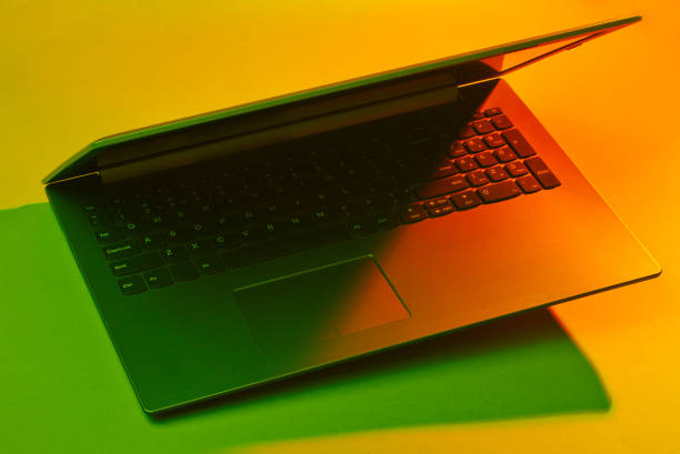 Modern laptop with vibrant gradient. color lights. Minimal office surrealism concept.
