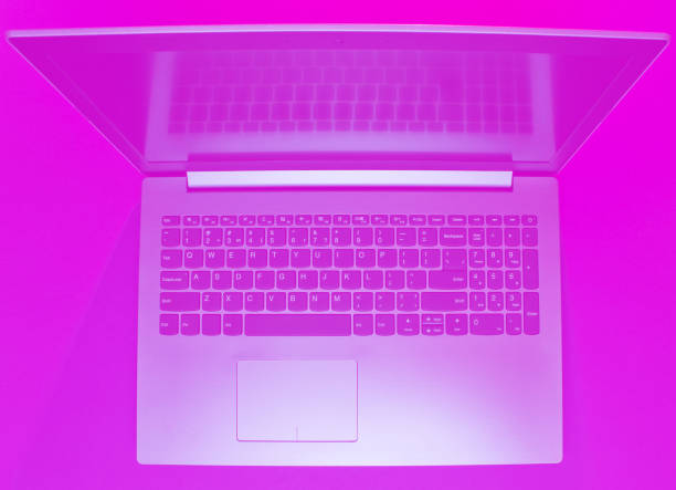 istock Modern laptop with vibrant pink tonned. Minimalism. Top view 1203211289