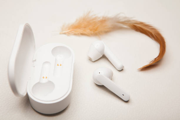 istock earphones feather white leather background 1203211296