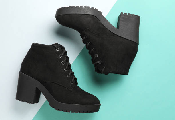 istock Black suede boots on paper background. Top view 1203212332