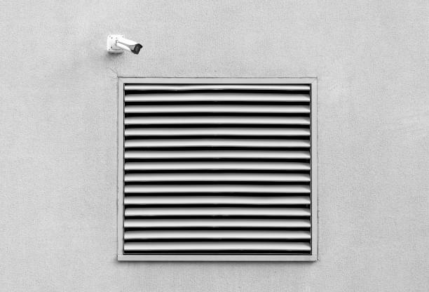 istock Industrial architecture detail with basement window and security camera 1203212774
