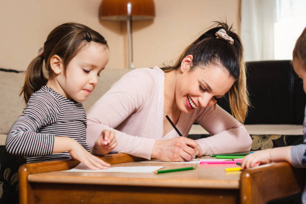 istock Happy mother drawing whit her children. 1203213022