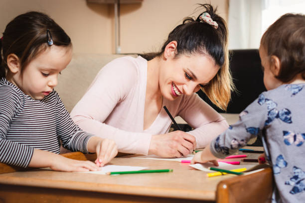 istock Happy mother drawing whit her children. 1203214144