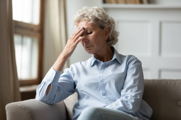 istock Frustrated nervous middle aged hoary woman touching forehead. 1203214390