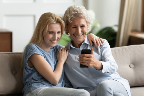 istock Smiling young lady hugs happy older mother, posing for selfie. 1203214407