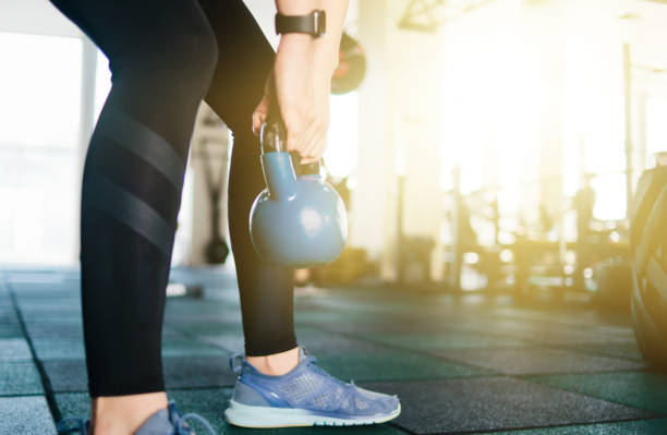 istock Functional training with a kettlebell. Closeup woman doing exercise with kettlebell in gym 1203214821