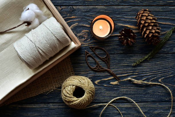 Handmade tools and burning candle on a dark wooden background. Top view. Close-up. Flat lay.