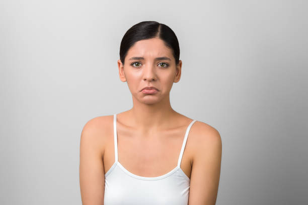 istock beautiful but unhappy woman on grey background. menstruation days begin 1203215444