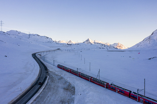 Swiss railway, red train passing through snowcapped landscape in the Swiss Alps, Bernina mountains, Graubunden, Switzerland