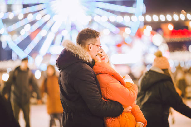 istock couple hugging in Saint Valentine's Day. Young romantic pair having fun outdoors in winter. St. Valentines Day at city ice rink. New Year holidays. active date ice skating on ice arena on Christmas 1203216415