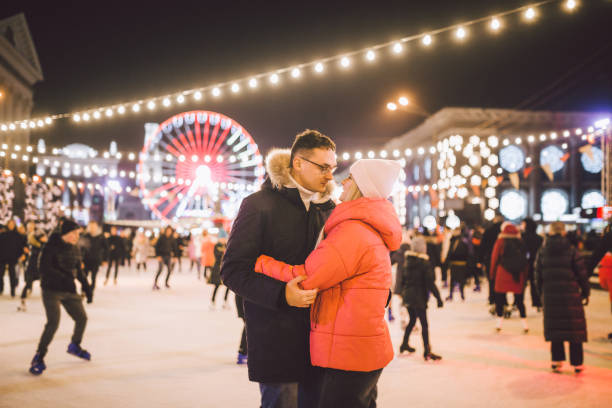 couple hugging in Saint Valentine's Day. Young romantic pair having fun outdoors in winter. St. Valentines Day at city ice rink. New Year holidays. active date ice skating on ice arena on Christmas. pareja abrazándose en san valentín. pareja romántica joven divirtiéndose al aire libre en invierno. día de san valentín en la pista de hielo de la ciudad. vacaciones de año nuevo. fecha activa patinaje sobre hielo en la arena de hielo en navidad