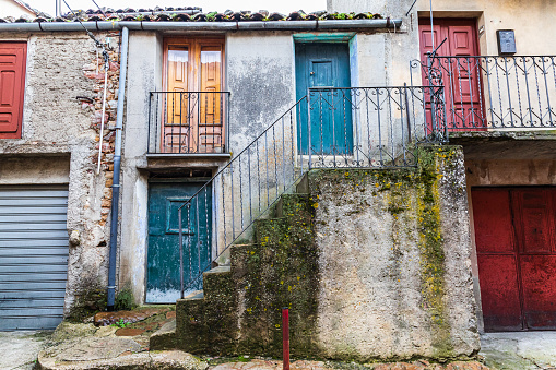 Italy, Sicily, Palermo Province, Geraci Siculo. Apartment building with colorful doors in the town of Geraci Siculo.