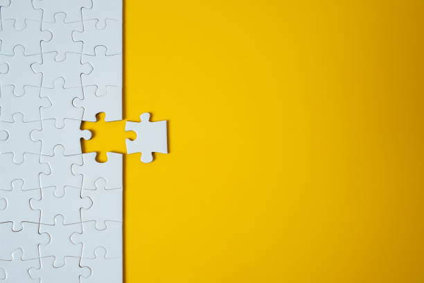 white jigsaw puzzle on yellow background. team business success partnership or teamwork. - color match imagens e fotografias de stock