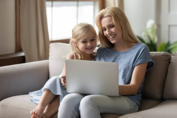 istock Happy mother showing educational apps to small daughter. 1203220209