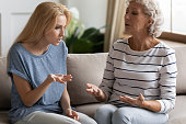 Blonde grown up daughter arguing with nervous old mature mother.