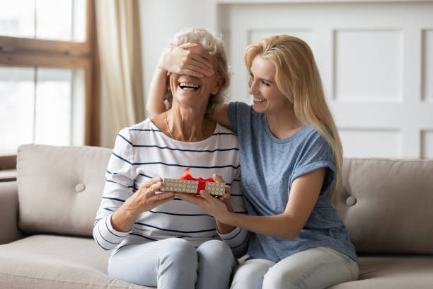 istock Smiling grown up daughter prepared surprise for mother. 1203220264