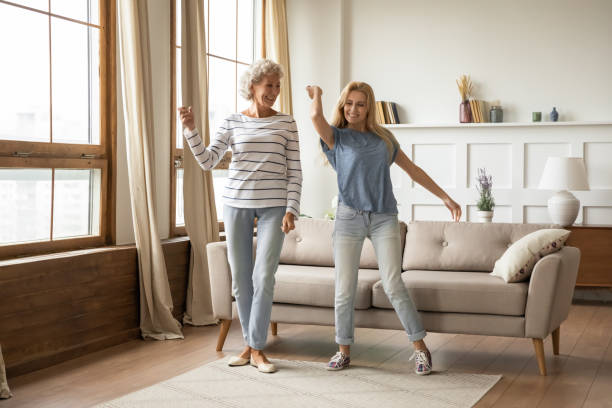 istock Overjoyed middle aged woman dancing with grown up daughter. 1203220278