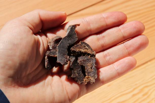 istock Biltong (dried meat) on a wooden board. 1203221770