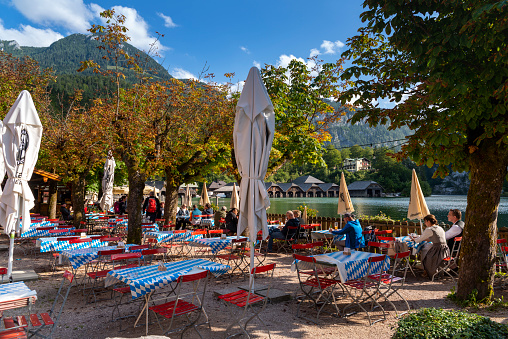 Schönau am Königssee, Germany - September 19, 2019: People in a cafe enjoying the nice view of the Koenigssee on a splendid day in autumn.
