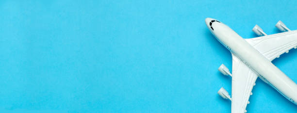 istock Travel minimal background banner. Model airplane in flight on an empty colored background. Copy space 1203224396