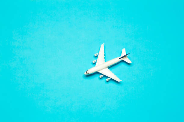 istock Travel minimal background. Model airplane in flight on an empty colored background. Copy space 1203224402