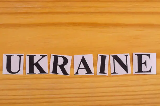 The word UKRAINE is laid out from pieces of paper with letters.