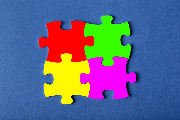 istock Four fastened puzzles of different colors on blue background 1203226499