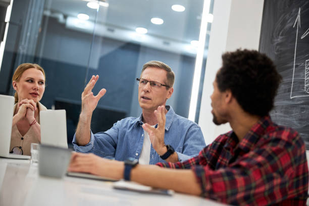 istock Gentleman sharing idea for business project with colleagues 1203227435