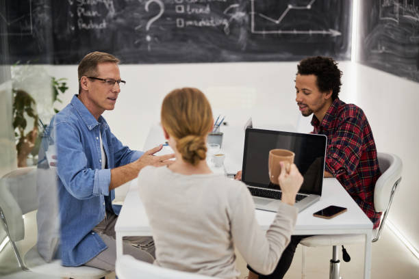 istock Business colleagues chatting and drinking coffee at work 1203227528