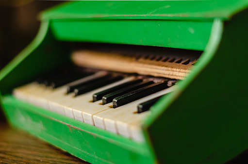 The old toy piano. Vintage toy for children. Side view. Selective focus. Eye level shooting.