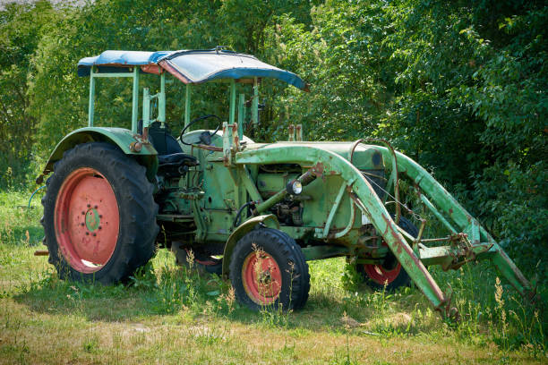 old discarded green tractor - agricultural machinery retro revival summer farm imagens e fotografias de stock