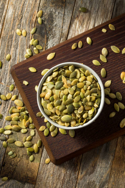 raw green organic pumpkin seed pepitas - pepita de calabaza fotografías e imágenes de stock