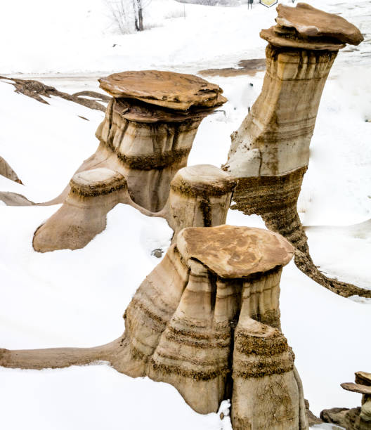 późny podmuch śniegu próbuje ukryć hoodoos w badlands. drumheller alberta, kanada. - steeple outdoors vertical alberta zdjęcia i obrazy z banku zdjęć