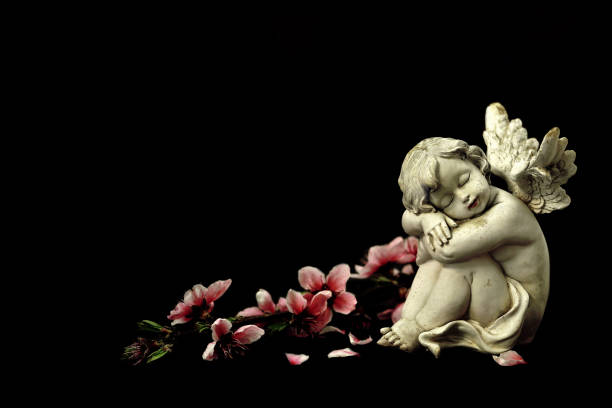 istock Guardian angel and spring flowers isolated on black 1203232537