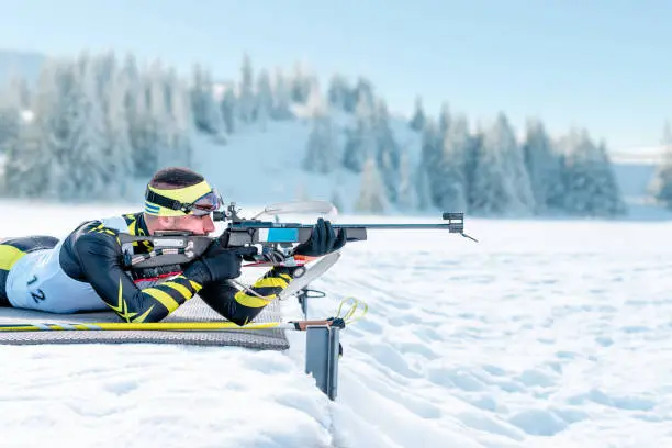 Biathlete shoots in the prone position on training ground