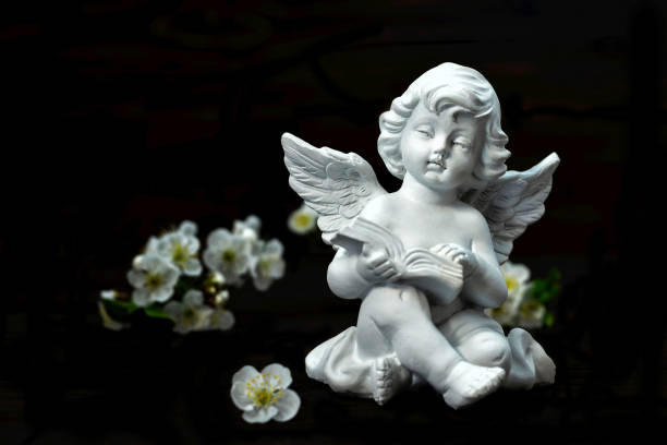 istock Guardian angel and spring flowers isolated on black background 1203232664