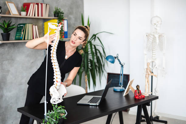 istock Cheerful female physiatrist teaching students about human skeleton 1203233816