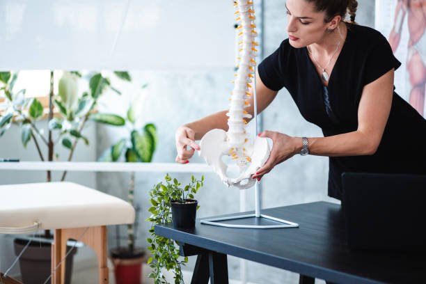 istock Serious female anatomy teacher showing students iliac bone 1203234041