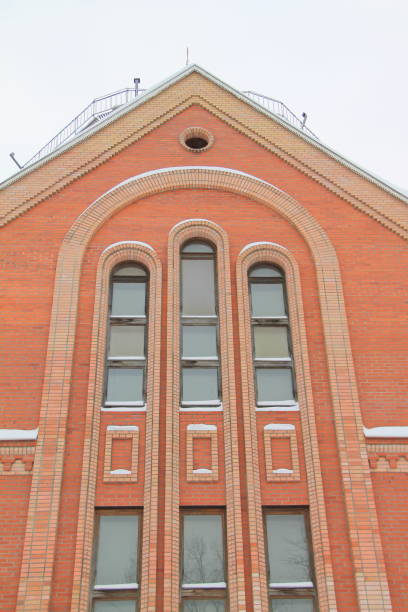 istock Fragment of a red brick church with windows 1203236265