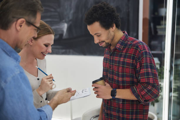 istock Cheerful colleagues working on business project together 1203236620