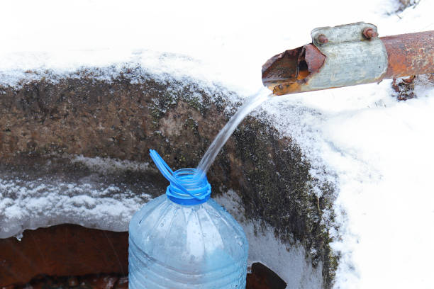 istock Pure natural water flows from the pipe into the bottle 1203239031