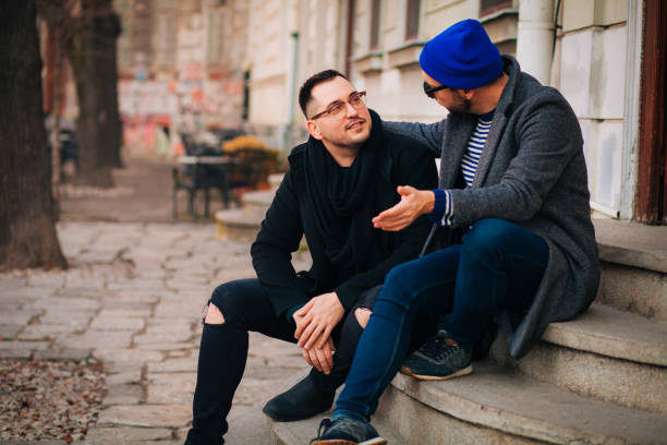istock Cheerful male speaking with outgoing comrade outside 1203239322