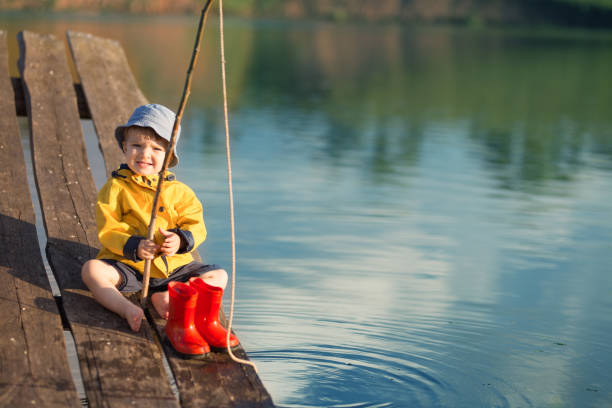 Boy on the wooden dock with a fishing net