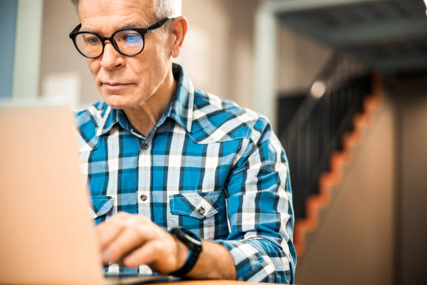 istock Mature male working with laptop at workplace 1203243627