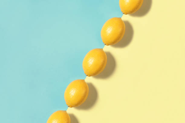 Lemons in a row on two toned blue and yellow background
