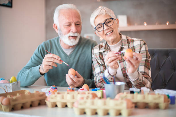 istock Happy couple painting Easter eggs. 1203244536