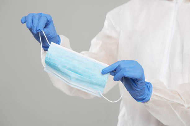 istock Doctors hands holding a protective mask against flu and viruses. 1203254470