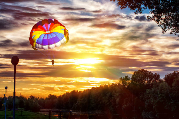 istock Gliding with a parachute on the background of sunset. 1203255459